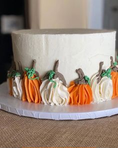 a white cake with orange and green decorations