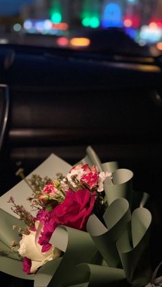 a bouquet of flowers sitting on top of a car dashboard