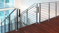 an empty room with wood flooring and metal railings