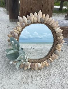 a mirror sitting on top of a sandy beach