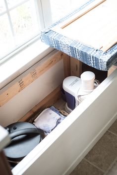 an open drawer in a kitchen next to a window