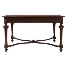 an antique wooden table with carved legs