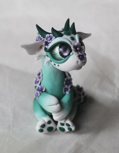 there is a figurine that looks like a dragon with flowers on its head