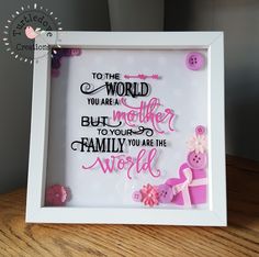 a white frame with pink and black words on it that says to the world you are a mother, but youre to your family you are the world