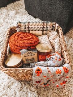 a basket filled with items sitting on top of a white rug next to a blanket