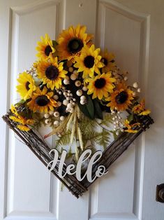 a wreath with sunflowers and the word hello on it hanging on a door