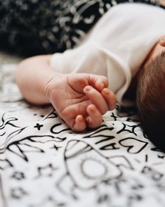 a close up of a baby laying on top of a bed