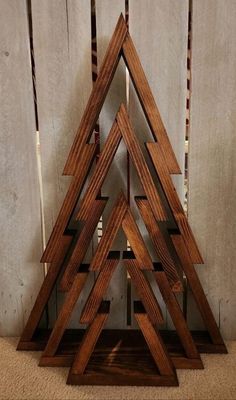 a wooden christmas tree sitting on top of a floor