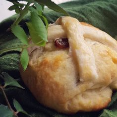 a close up of a pastry on a green cloth with leafy branches in the background