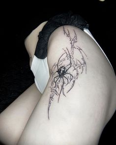 a woman with a spider tattoo on her thigh