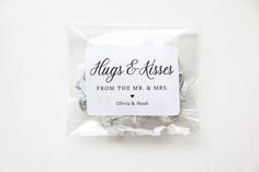 a package of wedding favors with the words hugs and kisses written on it in black ink