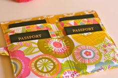 two passport holders sitting next to each other on top of a white table with pink and yellow flowers