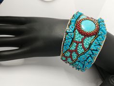 Beautiful and elegant bracelet in a slightly ethnic style, hand embroidered with a central turquoise cabochon and aulite gems. It is difficult and slow work, it took many hours of work from planning to realization of the final project. Each bead is individually hand sewn to create the final design. Inside the bracelet is covered in natural leather which gives a soft touch to the skin. This bracelet is comfortable to wear, goes perfectly with clothes of different colors. The colors used recall summer, the sea and the sun... The width of the bracelet is 4cm (1.6 inches). It has a brass plate inside that holds its shape and fits any wrist size. Wearing this bracelet will make you feel unique and special. Each piece is unique. If you would like a personalized bracelet in the colors of your cho Bohemian Handwork Jewelry As Gift, Unique Turquoise Beaded Bangle Bracelet, Artisan Beaded Turquoise Cuff Bracelet, Turquoise Beaded Cuff Bracelet Bangle, Artisan Turquoise Beaded Cuff Bracelet, Turquoise Beaded Cuff Bracelet For Gift, Bohemian Embroidered Adjustable Beaded Bracelets, Bohemian Blue Cuff Bracelet With Colorful Beads, Adjustable Beaded Blue Cuff Bracelet