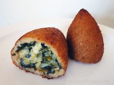 two pastries on a plate with spinach and cheese in the middle one is cut in half