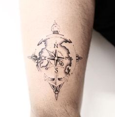 a man's arm with a compass tattoo on the left side of his leg