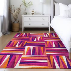 a bed room with a neatly made bed and a colorful rug