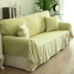 a living room with a green couch and pillows