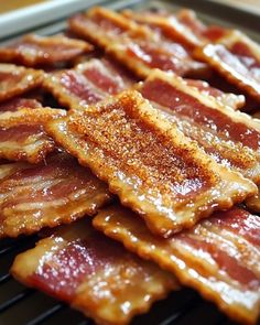 bacon on a grill with seasoning sprinkled over it's top and bottom