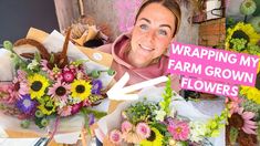 a woman holding flowers in front of a sign that says wrapping my farm grown flowers