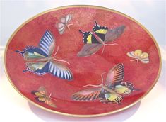 a red plate with butterflies painted on it