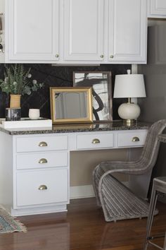 a white desk topped with a mirror next to a chair