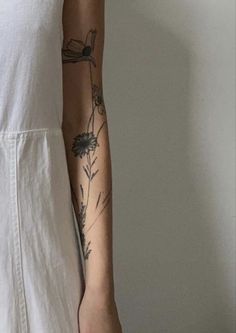 a woman with a tattoo on her arm holding a piece of paper in her hand