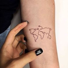 a woman's arm with a small world map tattoo on the left side of her arm