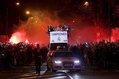 a group of people standing on top of a car in front of a large crowd