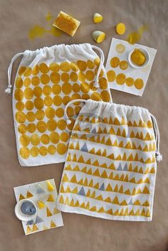 three drawsacks with yellow and white designs on them, next to some candy