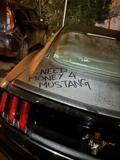 a car parked in front of a building with graffiti written on it's side