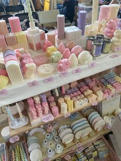 there are many different types of items on the shelf in this store, including soaps and candles