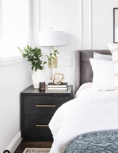 a bed with white sheets and pillows in a bedroom