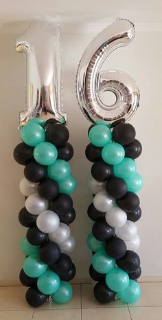 the number six is made out of balloons in black, white and aqua colors on display