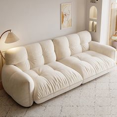 a white couch sitting next to a lamp in a living room