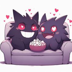 two black cats sitting on a couch with a bowl of popcorn in front of them