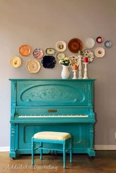 a blue piano sitting in front of a wall with plates on it