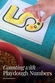 a child is playing with playdough numbers