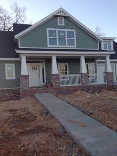 a house that is under construction in front of some trees and dirt on the ground