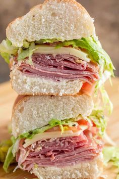 a cut in half sandwich sitting on top of a wooden cutting board