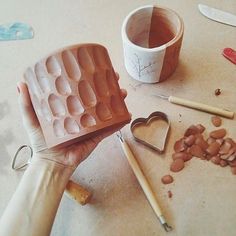 a person holding an ice cream mold in front of some other items on the table