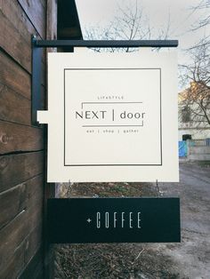 a sign hanging from the side of a wooden building next to a door with coffee written on it