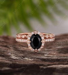 a black diamond ring on top of a piece of wood with leaves in the background