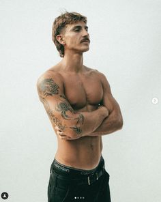 a shirtless man with his arms crossed