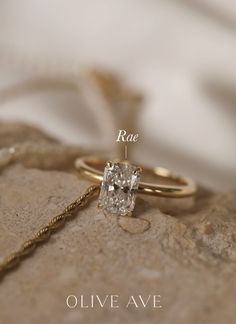 an engagement ring with a square cut diamond in the center, on top of a rock