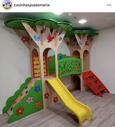 children's play area with slide, climbing wall and flowered trees on the walls