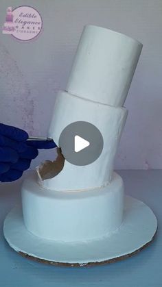 a person in blue gloves cutting into a white cake with a large roll of toilet paper