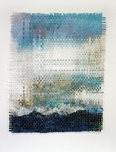 a piece of art made out of different colored squares and lines, with the ocean in the background