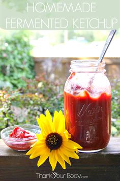 homemade fermented ketchup in a mason jar next to a sunflower