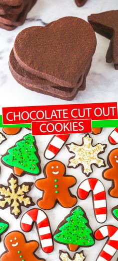 chocolate cut out cookies with christmas decorations and candy canes on the table next to them