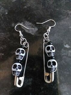 pair of earrings with skulls on them sitting on a table